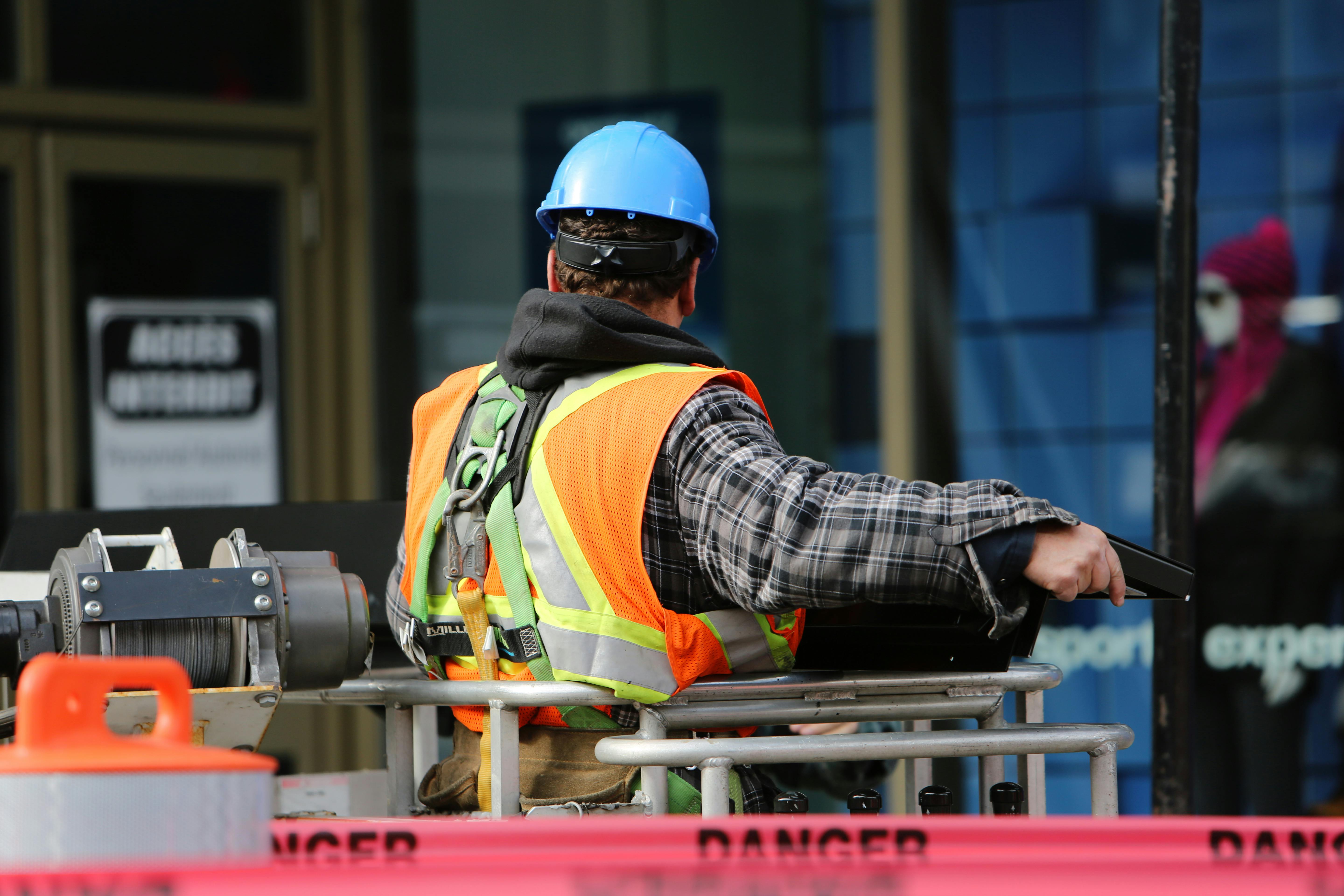 Worker in safety vest monitoring active construction site perimeter