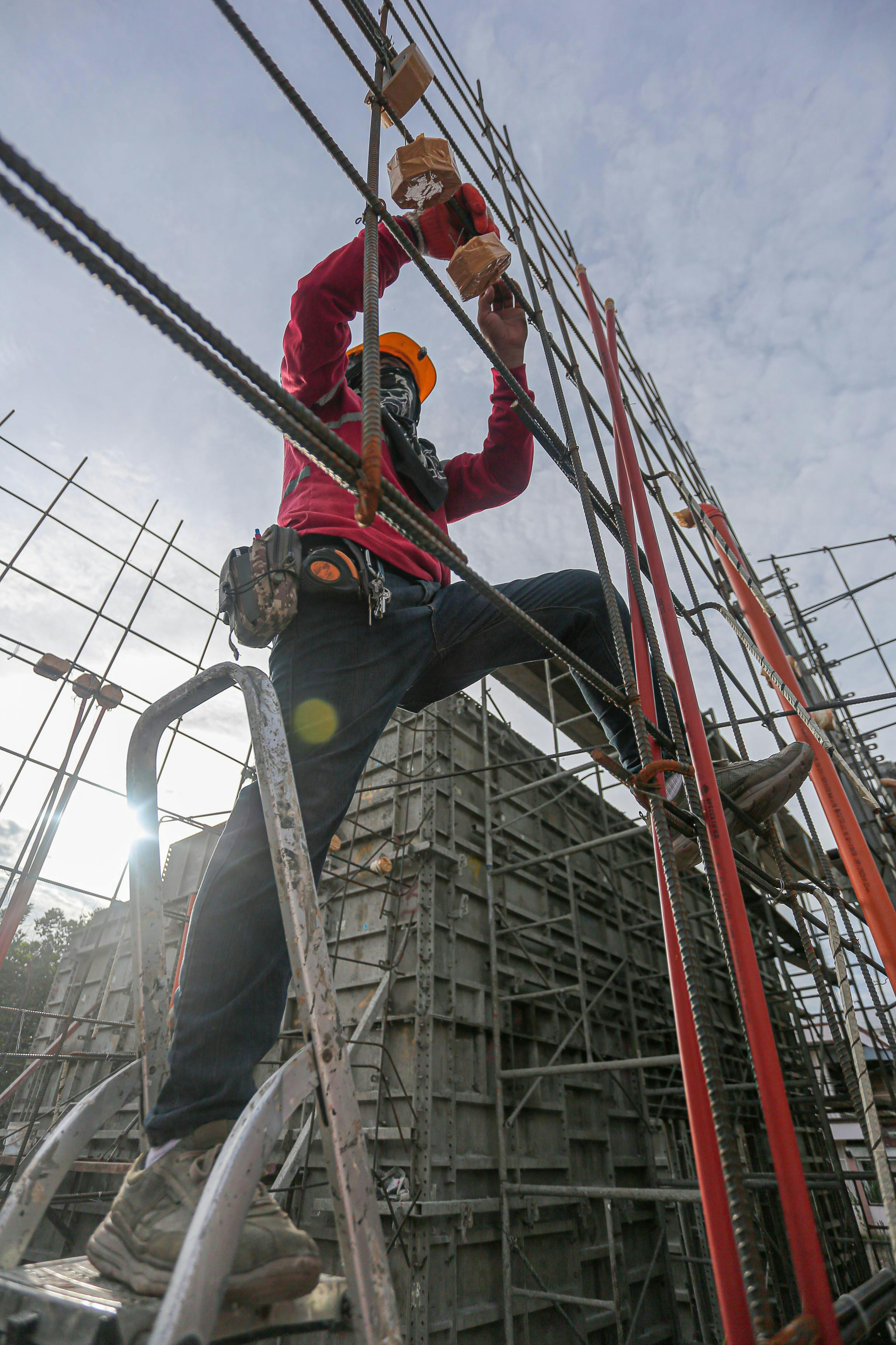 Field worker climbing ladder on an active construction site